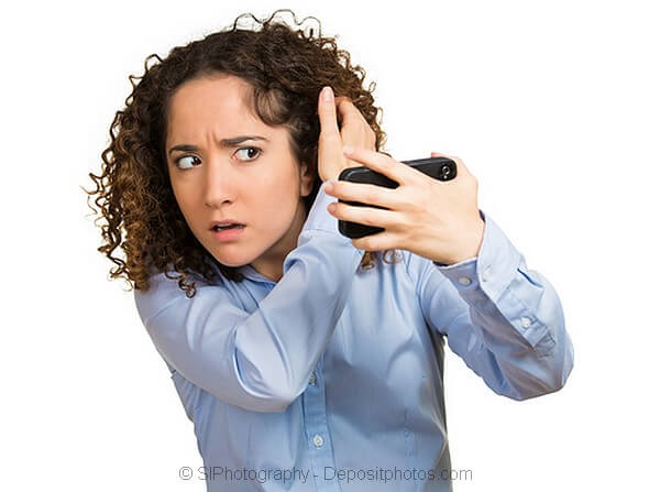 Lady worried about hair loss looking in the mirror